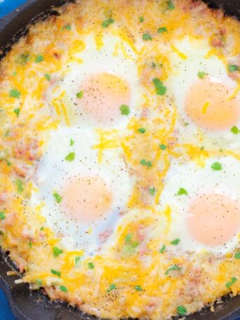 This Corned Beef Hash and Eggs is filled with tender potatoes, chunks of corned beef, green peppers, and spices. It's topped with eggs and a sprinkling of cheese, and then baked to perfection. If you're looking for a zesty breakfast or brunch option, then you'll love this flavorful skillet!