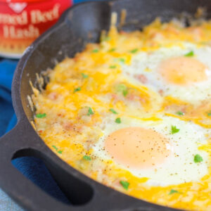 This Corned Beef Hash and Eggs is filled with tender potatoes, chunks of corned beef, green peppers, and spices. It's topped with eggs and a sprinkling of cheese, and then baked to perfection. If you're looking for a zesty breakfast or brunch option, then you'll love this flavorful skillet!