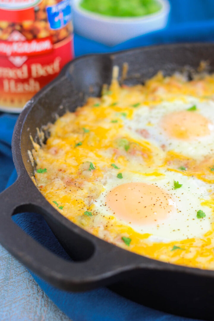 corned beef hash and eggs in a cast iron skillet, viewed from the side