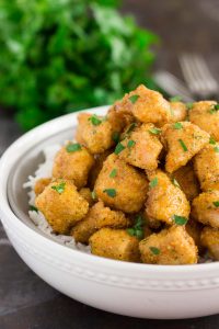 zoomed in shot of chunks of baked chicken over rice