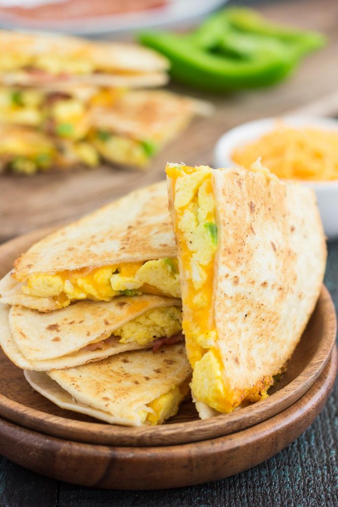 breakfast quesadilla slices on wood plates. 