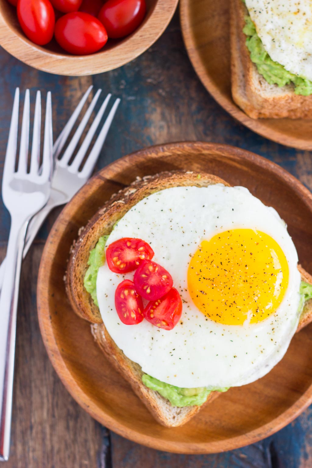 This Fried Egg and Avocado Toast is a deliciously simple way to jazz up your breakfast or snack. Hearty bread is toasted and then topped with mashed avocado, a fried egg, and cherry tomatoes. It’s ready in just minutes and is full of healthy ingredients!