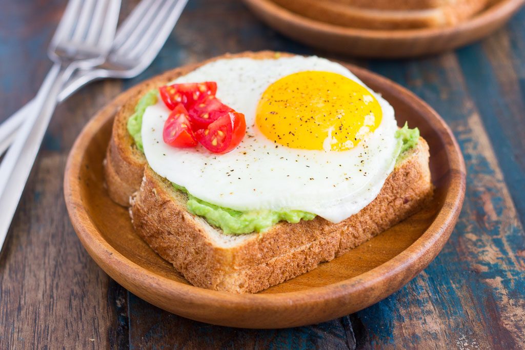This Fried Egg and Avocado Toast is a deliciously simple way to jazz up your breakfast or snack. Hearty bread is toasted and then topped with mashed avocado, a fried egg, and cherry tomatoes. It’s ready in just minutes and is full of healthy ingredients!
