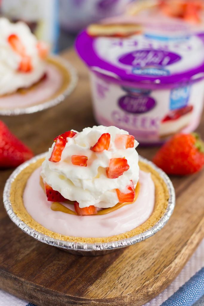 These Mini Strawberry Peanut Butter Cheesecake Pies are filled with Dannon® Light & Fit® Strawberry Cheesecake Greek Yogurt, creamy peanut butter, and fresh strawberries. Easy to make and packed with flavor, you can enjoy this no-bake, simple dessert that's perfect for the warmer weather!