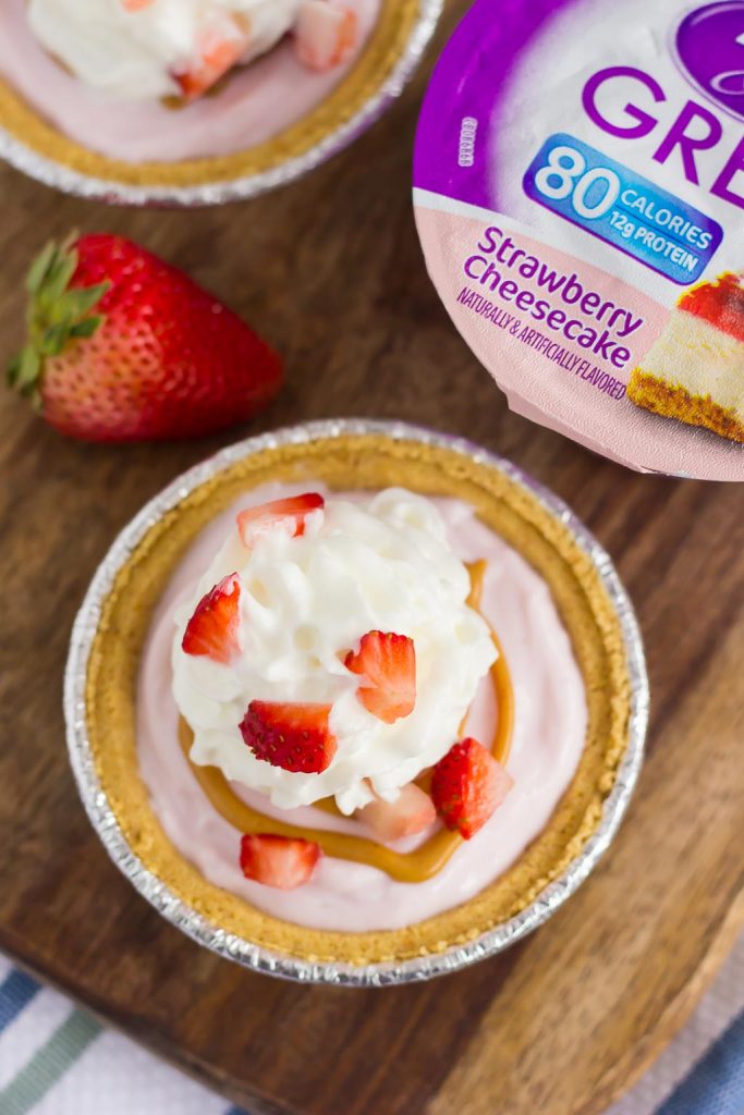 These Mini Strawberry Peanut Butter Cheesecake Pies are filled with Dannon® Light & Fit® Strawberry Cheesecake Greek Yogurt, creamy peanut butter, and fresh strawberries. Easy to make and packed with flavor, you can enjoy this no-bake, simple dessert that's perfect for the warmer weather!