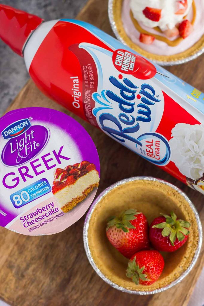These Mini Strawberry Peanut Butter Cheesecake Pies are filled with Dannon® Light & Fit® Strawberry Cheesecake Greek Yogurt, creamy peanut butter, and fresh strawberries. Easy to make and packed with flavor, you can enjoy this no-bake, simple dessert that's perfect for the warmer weather!