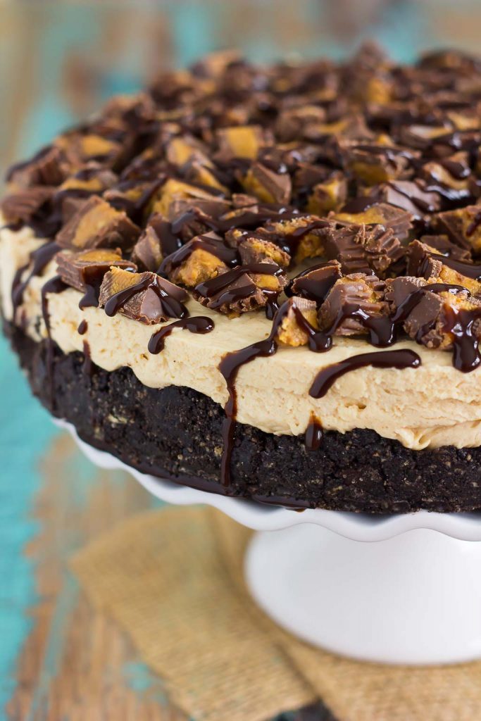 This No-Bake Peanut Butter Cup Cheesecake starts with an Oreo peanut butter cookie crust, followed by a creamy, peanut butter batter, and sprinkled with chopped peanut butter cups and chocolate syrup. It's an easy dessert that takes just minutes to prepare and is packed with flavor!