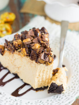 This No-Bake Peanut Butter Cup Cheesecake starts with an Oreo peanut butter cookie crust, followed by a creamy, peanut butter batter, and sprinkled with chopped peanut butter cups and chocolate syrup. It's an easy dessert that takes just minutes to prepare and is packed with flavor!