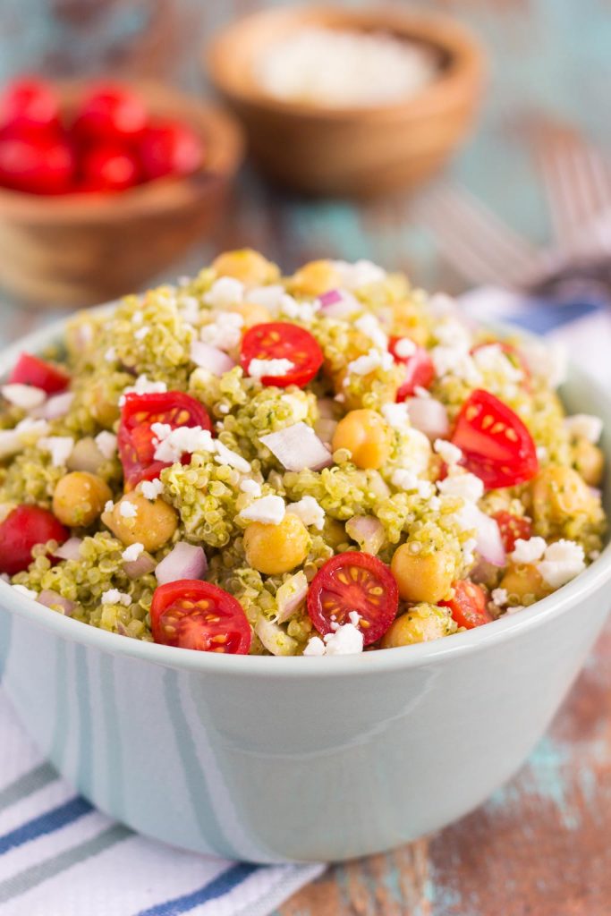 This Quinoa and Chickpea Pesto Salad is filled with chickpeas, hearty quinoa, cherry tomatoes, red onions, and crumbled feta cheese. It's tossed with a zesty pesto sauce that packs a punch of flavor in every bite. It's easy to prepare and makes simple dish that's perfect for lunch or dinner! #quinoa #quinoasalad #quinoabowl #pesto #pestosalad #chickpeas #chickpeasalad #saladrecipe #healthysalad #healthylunch
