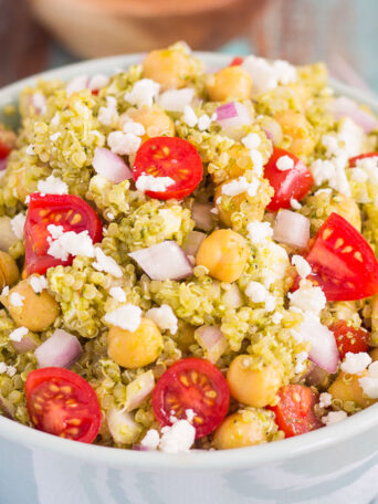 This Quinoa and Chickpea Pesto Salad is filled with chickpeas, hearty quinoa, cherry tomatoes, red onions, and crumbled feta cheese. It's tossed with a zesty pesto sauce that packs a punch of flavor in every bite. It's easy to prepare and makes simple dish that's perfect for lunch or dinner!