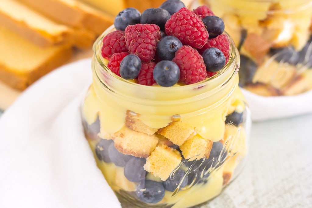 A summer berry trifle with pound cake cubes in a glass jar. 