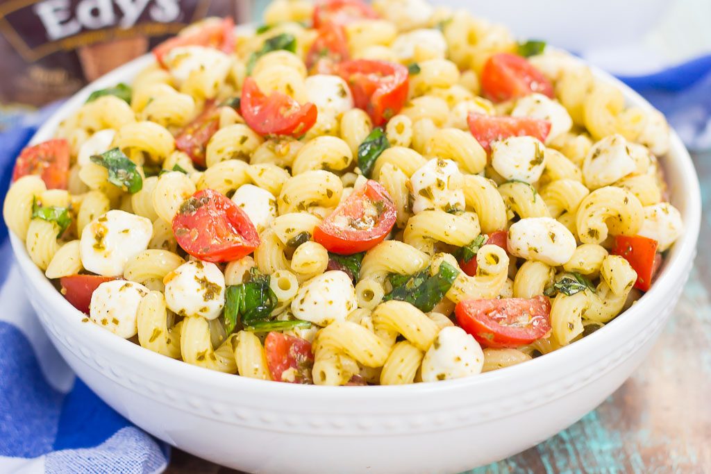 bowl of caprese pesto pasta salad on blue towel