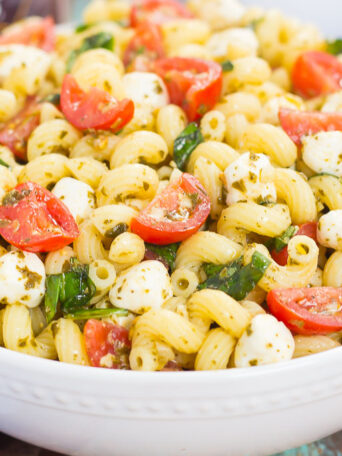 This Caprese Pasta Salad is filled with tender noodles, cherry tomatoes, fresh basil, and creamy mozzarella cheese. It's tossed in a white balsamic and pesto dressing, which gives this dish a burst of flavor. Simple, fresh, and full of flavor, this pasta salad is ready in minutes and is perfect for summer!