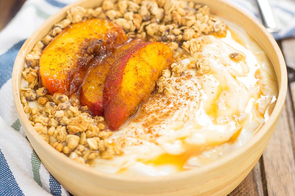 This Grilled Peach Caramel Yogurt Bowl is filled with creamy, vanilla Greek yogurt, grilled peaches with cinnamon and brown sugar, a sweet caramel sauce, and crunchy granola. It's ready in minutes and makes the perfect breakfast or snack!