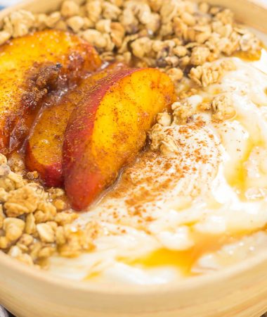 This Grilled Peach Caramel Yogurt Bowl is filled with creamy, vanilla Greek yogurt, grilled peaches with cinnamon and brown sugar, a sweet caramel sauce, and crunchy granola. It's ready in minutes and makes the perfect breakfast or snack!