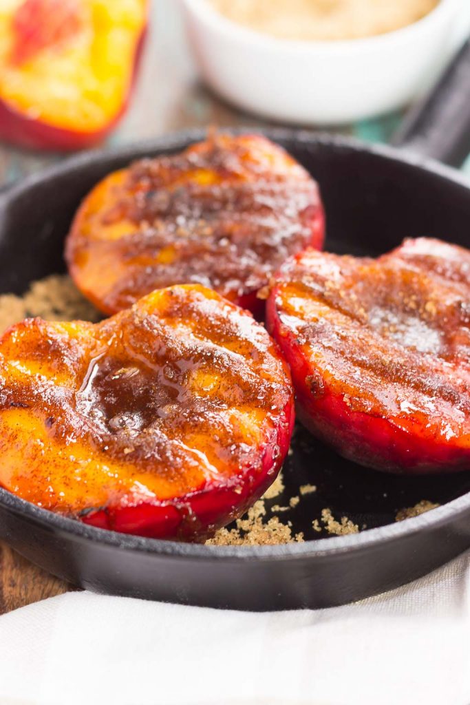 Three bbq peaches in a cast iron skillet.