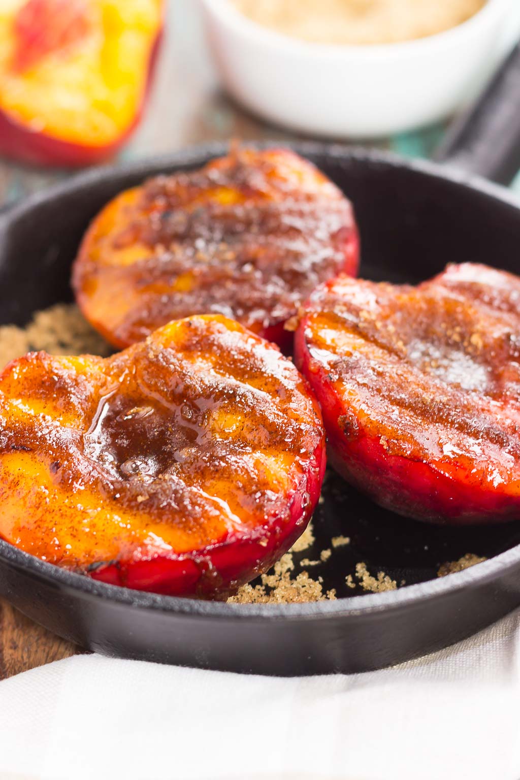 Three bbq peaches in a cast iron skillet.