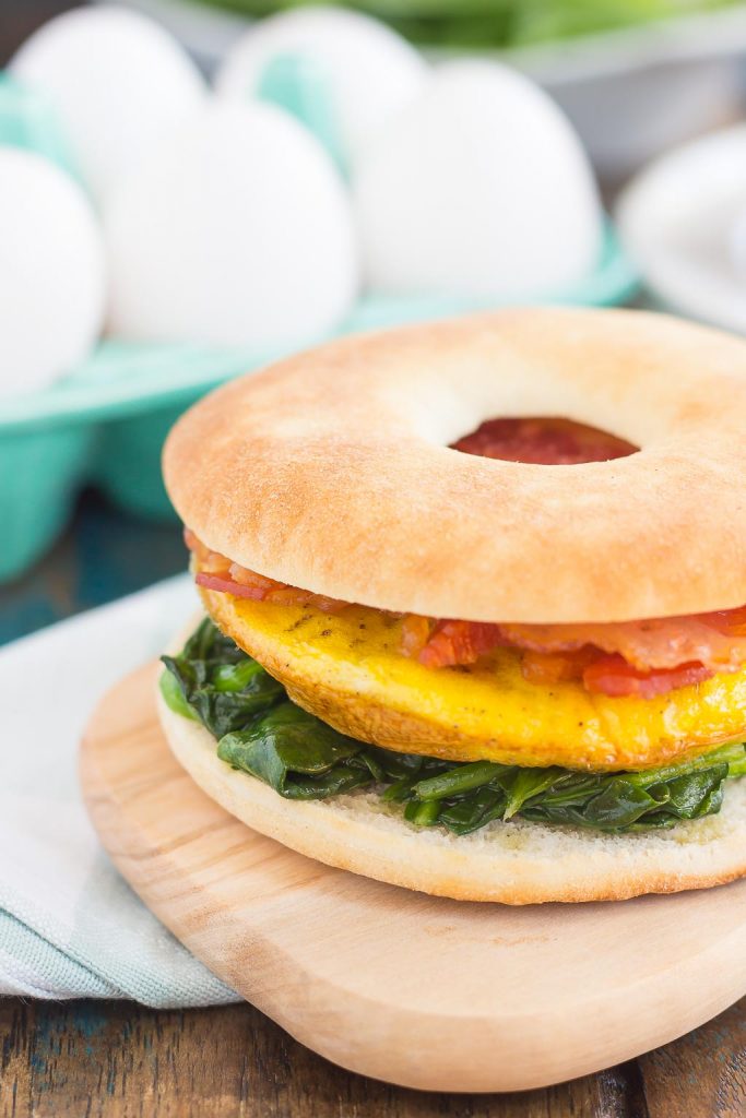 This Spinach, Bacon and Feta Breakfast Sandwich is an easy, make-ahead dish that's full of fresh ingredients. Fluffy eggs are seasoned with creamy feta cheese, and then topped sautéed spinach and smoky bacon. This sandwich makes a delicious and hearty breakfast for those busy weekday mornings!