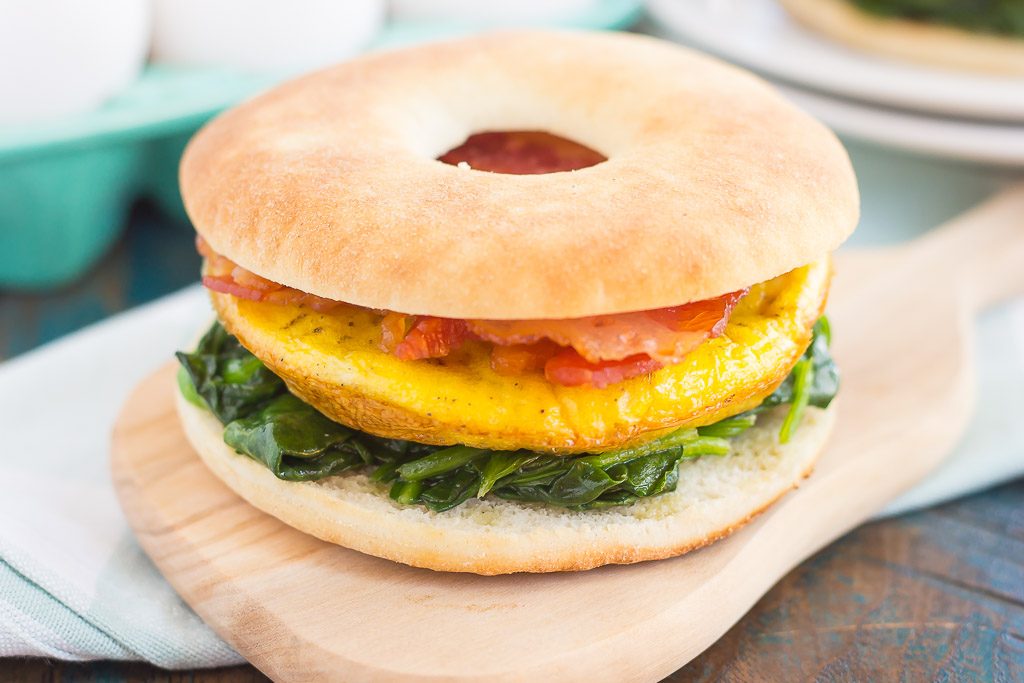 This Spinach, Bacon and Feta Breakfast Sandwich is an easy, make-ahead dish that's full of fresh ingredients. Fluffy eggs are seasoned with creamy feta cheese, and then topped sautéed spinach and smoky bacon. This sandwich makes a delicious and hearty breakfast for those busy weekday mornings!