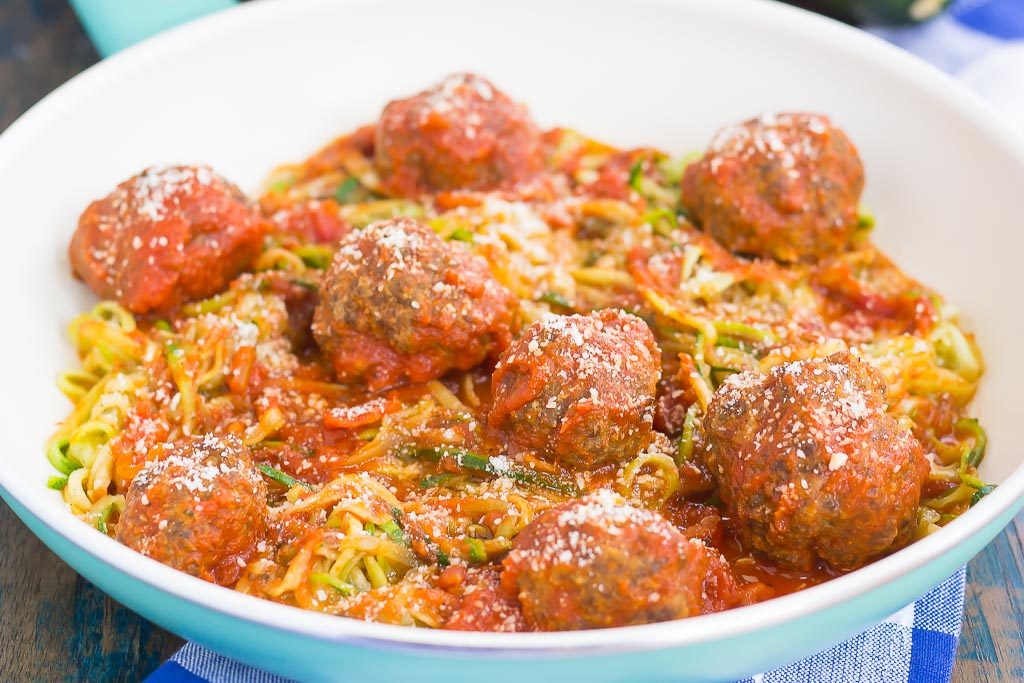 A skillet of zucchini noodles and meatballs. 