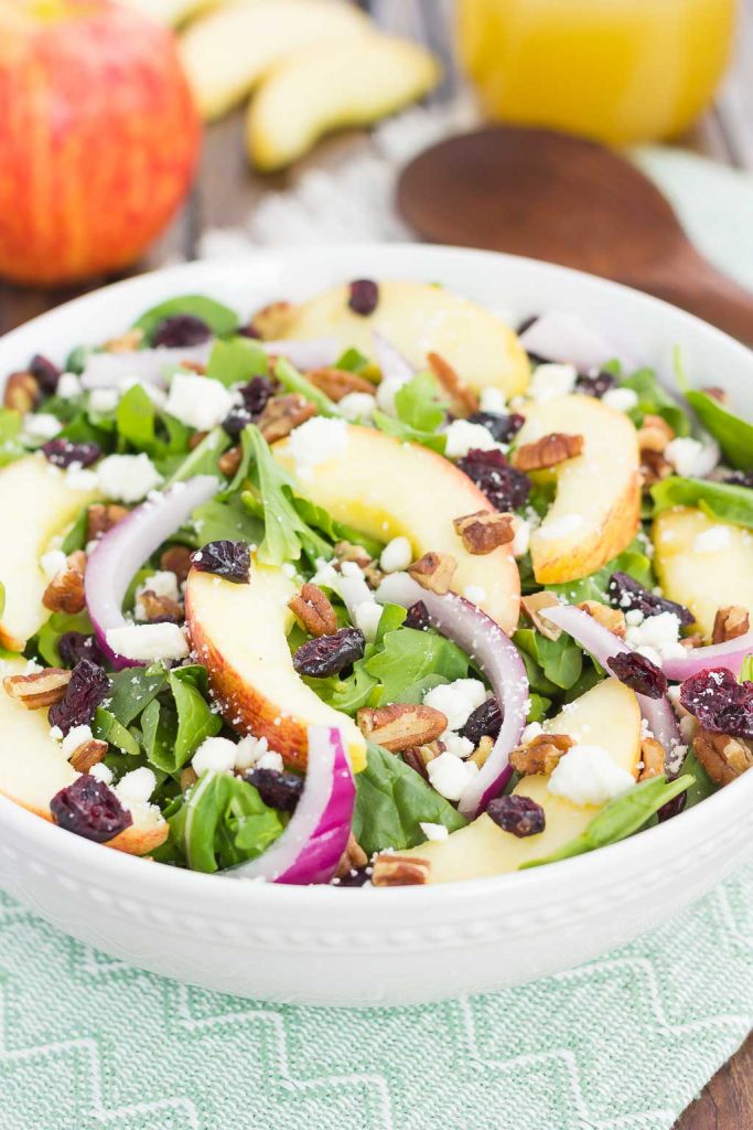 an apple cranberry salad in a large white bowl 