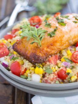 This Honey Garlic Salmon Quinoa Bowl is a flavorful and delicious, protein-packed meal. It's filled with hearty quinoa, fresh corn, cherry tomatoes, and herbs. Tossed in a simple, white balsamic dressing and served with salmon seasoned with a honey garlic sauce, this easy dish is ready in just 30 minutes and full of flavor!
