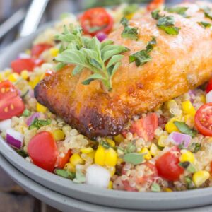 This Honey Garlic Salmon Quinoa Bowl is a flavorful and delicious, protein-packed meal. It's filled with hearty quinoa, fresh corn, cherry tomatoes, and herbs. Tossed in a simple, white balsamic dressing and served with salmon seasoned with a honey garlic sauce, this easy dish is ready in just 30 minutes and full of flavor!