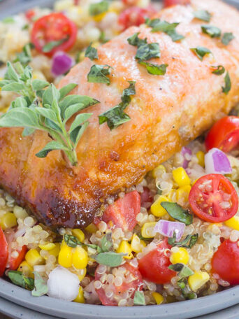 This Honey Garlic Salmon Quinoa Bowl is a flavorful and delicious, protein-packed meal. It's filled with hearty quinoa, fresh corn, cherry tomatoes, and herbs. Tossed in a simple, white balsamic dressing and served with salmon seasoned with a honey garlic sauce, this easy dish is ready in just 30 minutes and full of flavor!