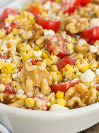 Grilled Garlic Herb Corn and Tomatoes with Walnuts is an easy side dish that's ready in minutes. Fresh corn off the cob, cherry tomatoes, feta cheese, and walnuts give this dish a flavorful punch that's perfect to pair alongside your favorite meal!