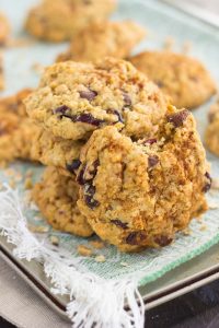 chewy oatmeal cranberry cookies in a pile with a bite taken out