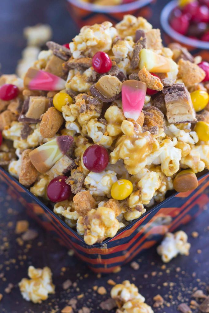 This Peanut Butter Candy Popcorn is the perfect sweet and salty snack to satisfy your sweet tooth! It makes the best snack to munch on during Halloween, and is also a great way to use up that leftover candy! #popcorn #popcornrecipe #peanutbutter #peanutbutterpopcorn #candy #halloween #halloweenrecipe #halloweensnack #halloweenpopcorn #appetizer #snack #recipe
