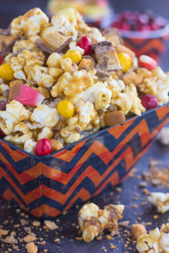 This Peanut Butter Candy Popcorn is the perfect sweet and salty snack to satisfy your sweet tooth! It makes the best snack to munch on during Halloween, and is also a great way to use up that leftover candy! #popcorn #popcornrecipe #peanutbutter #peanutbutterpopcorn #candy #halloween #halloweenrecipe #halloweensnack #halloweenpopcorn #appetizer #snack #recipe