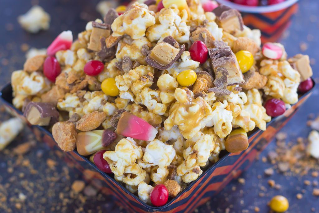 This Peanut Butter Candy Popcorn is the perfect sweet and salty snack to satisfy your sweet tooth! Fresh popcorn is coated with a creamy peanut butter mixture and then tossed with a variety of candies. It makes the best snack to munch on during Halloween, and is also a great way to use up that leftover candy!