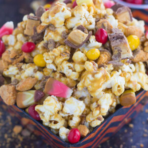 This Peanut Butter Candy Popcorn is the perfect sweet and salty snack to satisfy your sweet tooth! Fresh popcorn is coated with a creamy peanut butter mixture and then tossed with a variety of candies. It makes the best snack to munch on during Halloween, and is also a great way to use up that leftover candy!