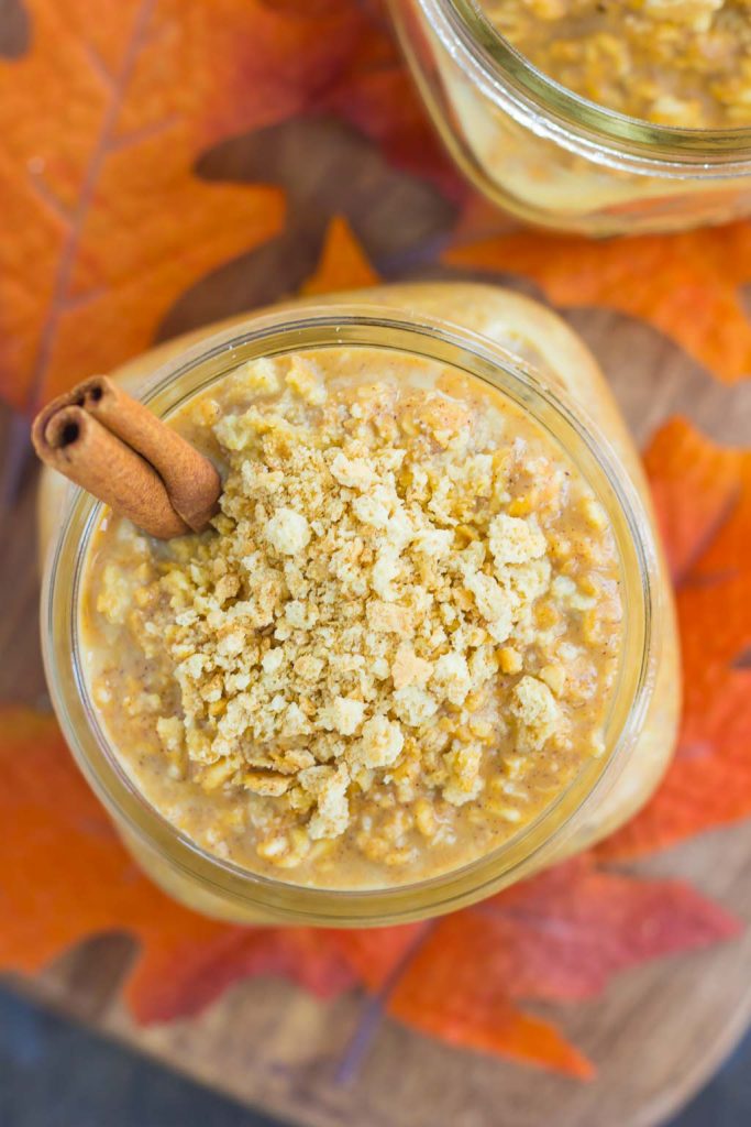 overhead view of two jars of pumpkin overnight oats garnished with cinnamon sticks