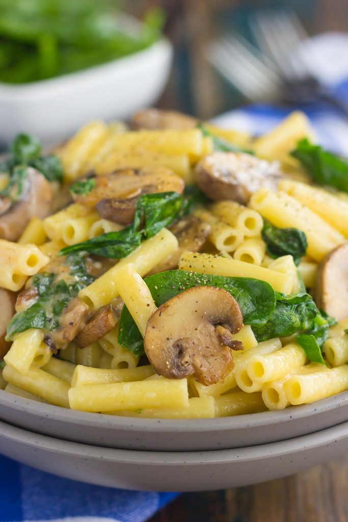 vegetarian mushroom and spinach pasta in gray bowl
