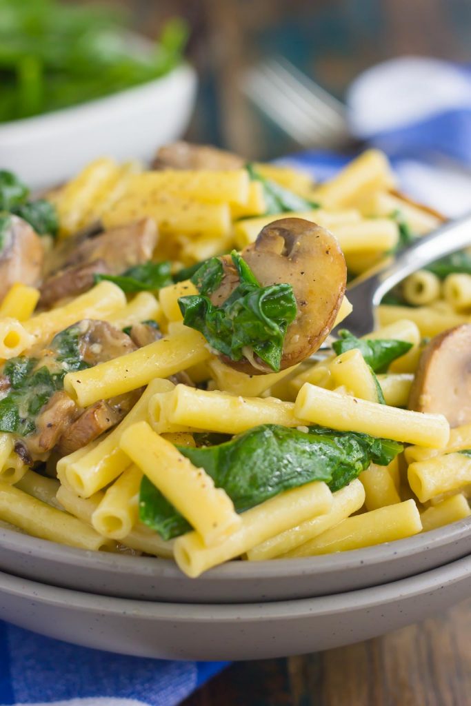 bowl of mushroom and spinach pasta with fork 