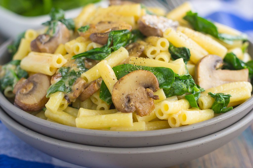 bowl full of garlic parmesan pasta with spinach and mushrooms