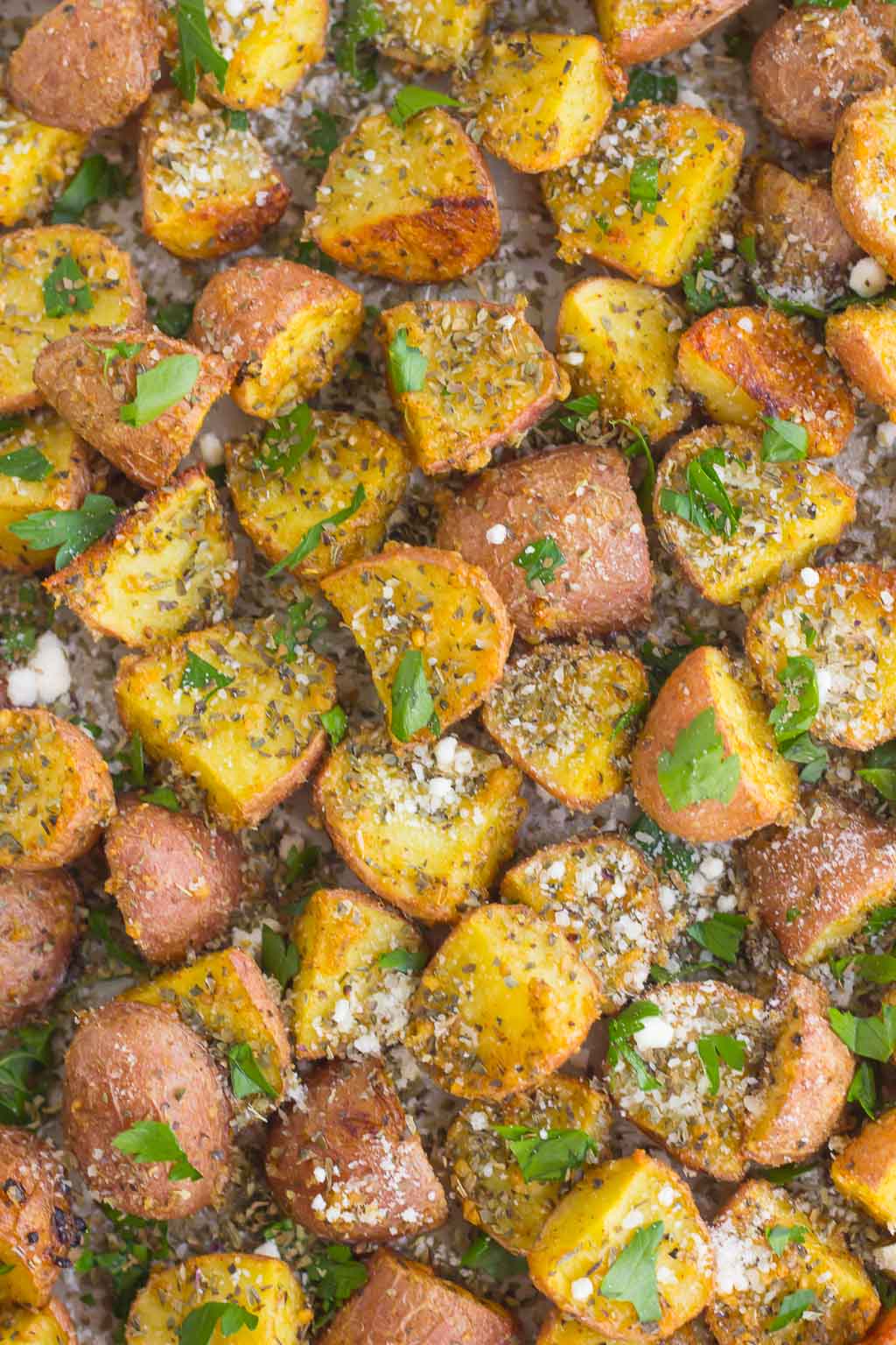 These Herb Roasted Potatoes are seasoned with Parmesan cheese, a variety of spices, and baked to perfection. Crispy on the outside and tender on the inside, this easy side dish comes together in minutes and is sure to be the hit of the dinner table!