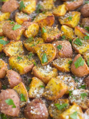 These Herb Roasted Potatoes are seasoned with Parmesan cheese, a variety of spices, and baked to perfection. Crispy on the outside and tender on the inside, this easy side dish comes together in minutes and is sure to be the hit of the dinner table!