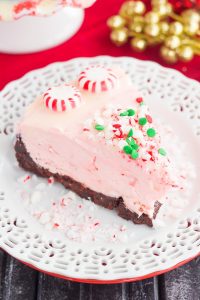 slice of no bake peppermint bark cheesecake on a white plate 
