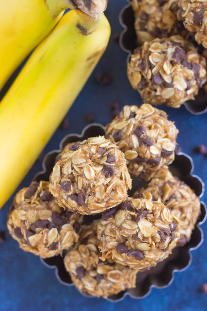 overhead view of no bake banana energy bites in a metal dish next to a bunch of bananas 