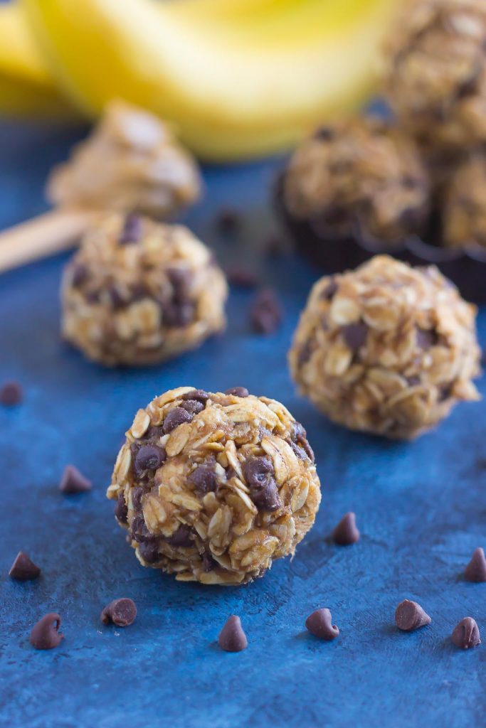 three no bake energy bites on a blue surface 