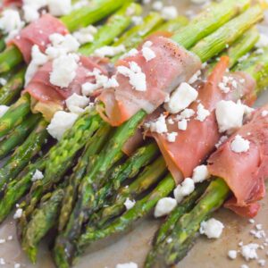 Fresh asparagus is wrapped in thin slices of prosciutto, roasted to perfection and then topped with crumbed feta cheese. Salty, crispy and packed with flavor, this Prosciutto Wrapped Asparagus with Feta makes an easy and delicious side dish!