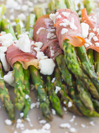 Fresh asparagus is wrapped in thin slices of prosciutto, roasted to perfection and then topped with crumbed feta cheese. Salty, crispy and packed with flavor, this Prosciutto Wrapped Asparagus with Feta makes an easy and delicious side dish!