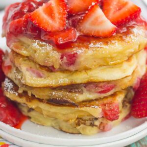These Strawberry Greek Yogurt Pancakes are thick, fluffy, and loaded with juicy strawberries in every bite. Made with Greek yogurt for a healthier twist and topped with an easy strawberry sauce, you're going to fall in love with the sweet taste of these pancakes!