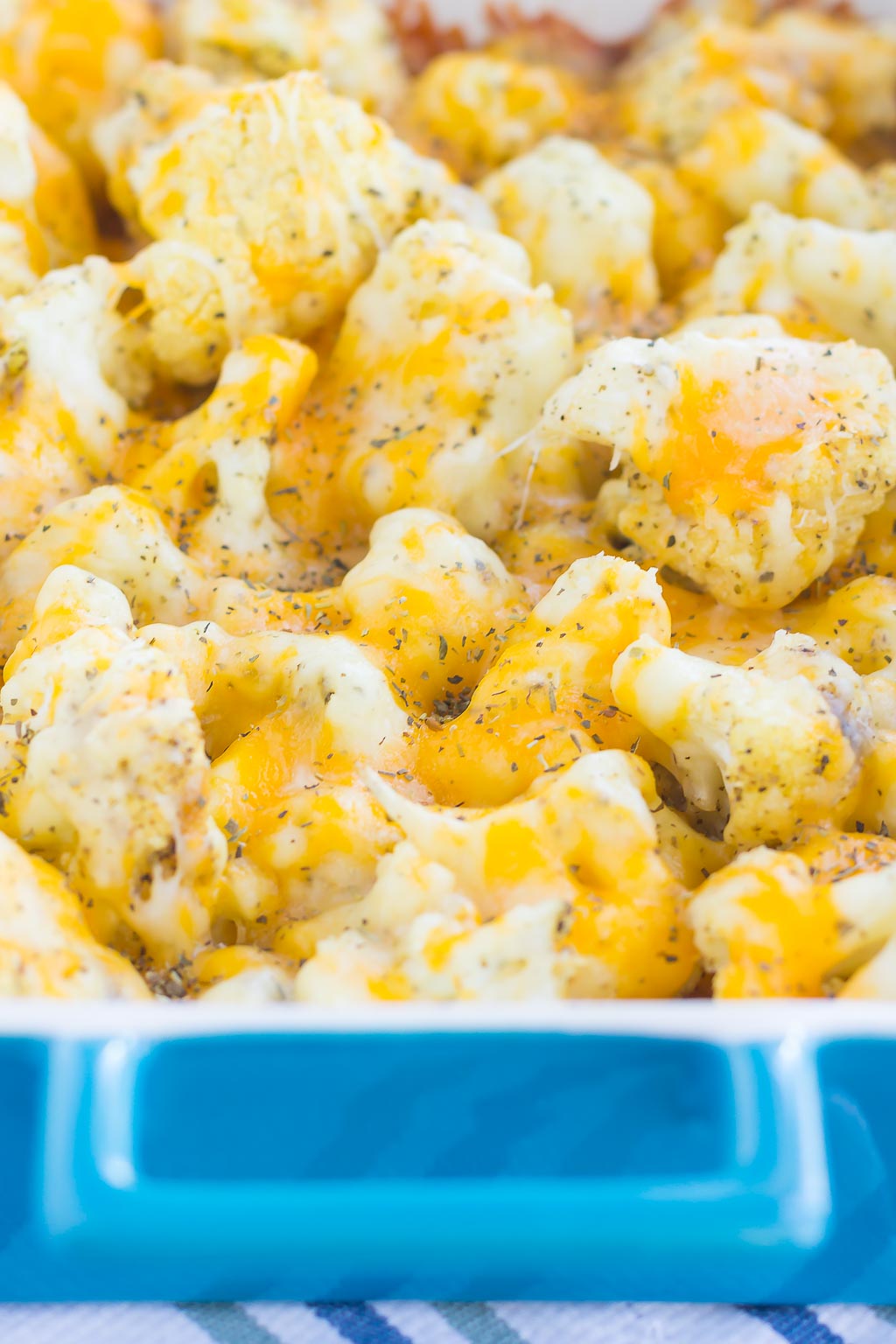 This Baked Cheesy Cauliflower is delicious way to jazz up your favorite veggie. Cauliflower florets are drizzled with olive oil, a blend of seasonings, and topped with two kinds of cheese. Baked until tender and oozing with flavor, this easy vegetable will quickly become a new mealtime favorite!