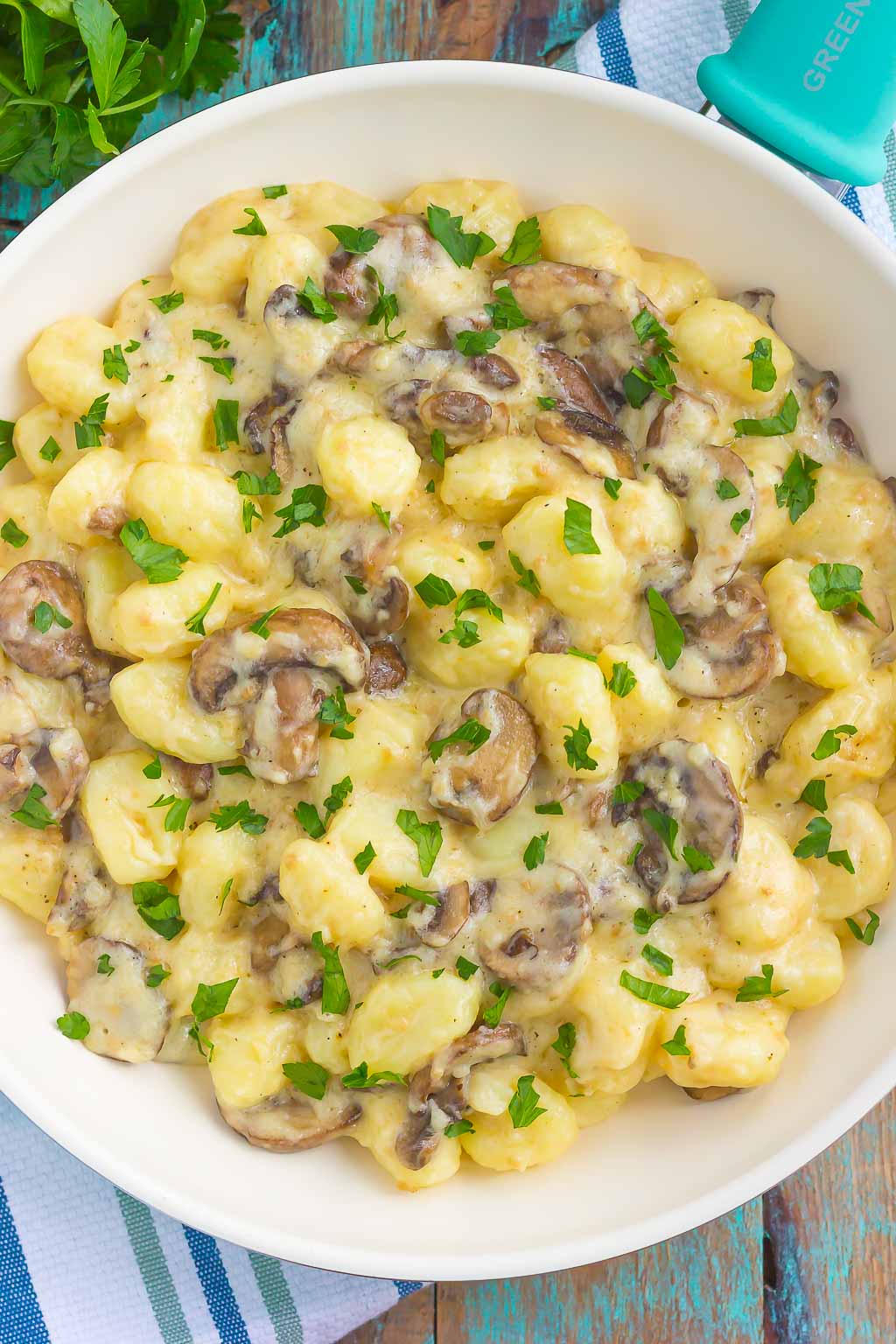 This Garlic Parmesan Gnocchi with Mushrooms is packed with flavor and makes a delicious 30 minute meal. Tender gnocchi is tossed in a garlic Parmesan cream sauce and sprinkled with sauteed mushrooms. Fast, fresh, and easy to make, this will become a new favorite in your dinner rotation!