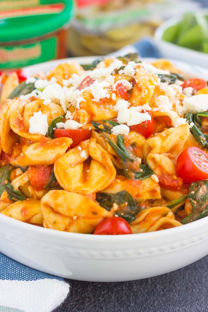 This Spinach and Feta Tortellini is fresh, flavorful, and ready in less than 30 minutes. Cheese tortellini is tossed in a zesty marinara sauce and sprinkled with fresh spinach and crumbled feta cheese. Easy to make and perfect for busy weeknights, this warm and comforting pasta will fill you up and keep you coming back for more! #tortellini #spinach #spinachtortellini #feta #spinachpasta #pasta #dinner #easydinner