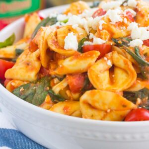 This Spinach and Feta Tortellini is fresh, flavorful, and ready in less than 30 minutes. Cheese tortellini is tossed in a zesty marinara sauce and sprinkled with fresh spinach and crumbled feta cheese. Easy to make and perfect for busy weeknights, this warm and comforting pasta will fill you up and keep you coming back for more!